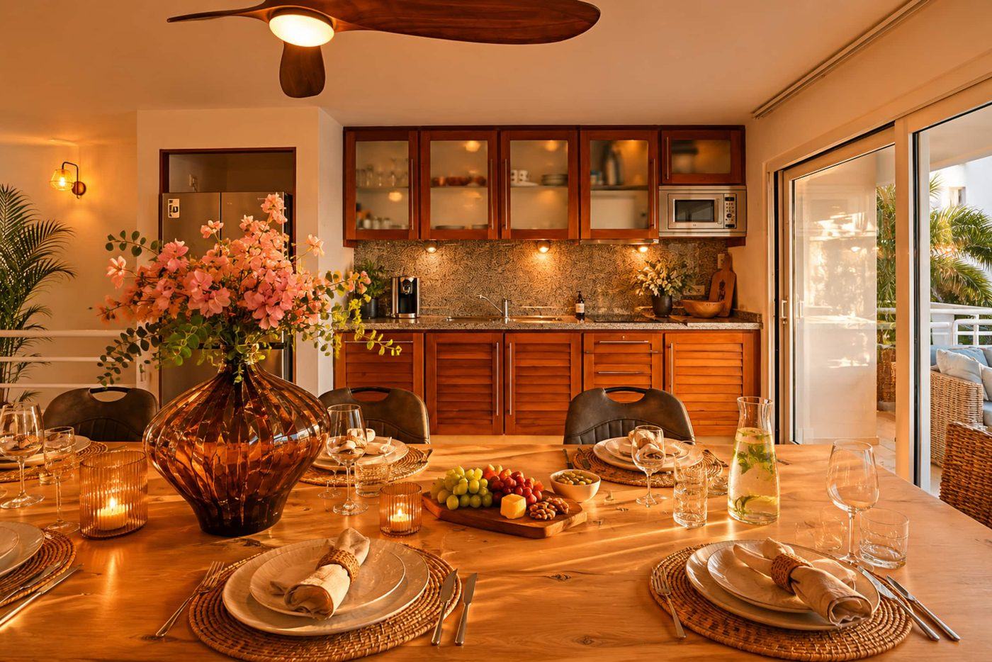 Dolphin apartment: large designer dining table set for dinner, with the kitchen behind
